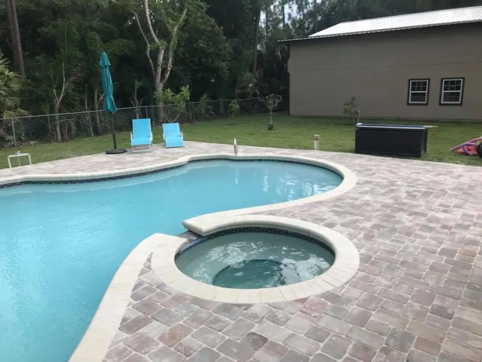 Paver pool deck around a pool and raised spa